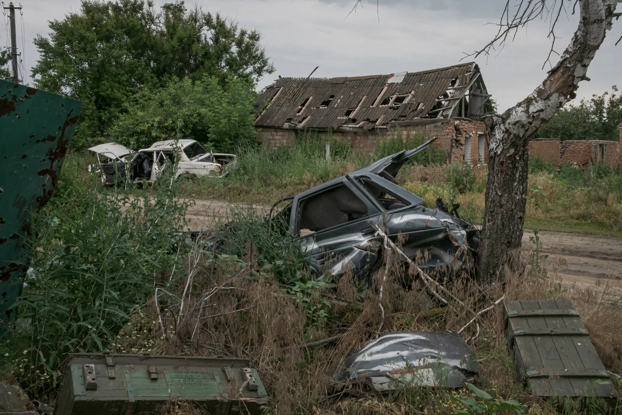 Порожні ящики від боєприпасів і знищений цивільний автомобіль із символікою «Z» російських військ у селі Кам’янка на сході України.